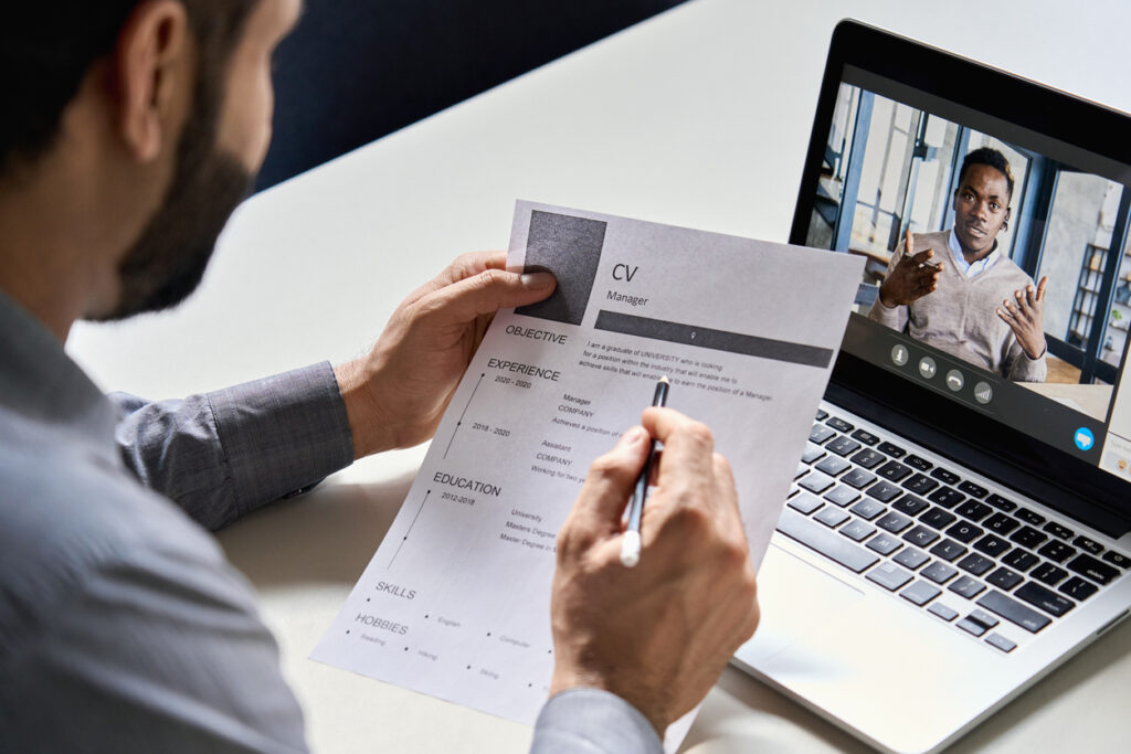 Man holding cv having online virtual job interview meeting with a candidate on video call