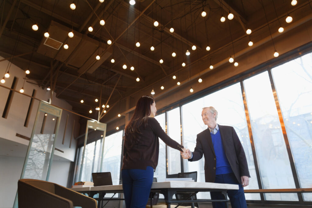 man and woman shaking hands for the woman's onboarding experience