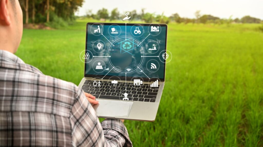 a man in a field using his laptop to work smarter