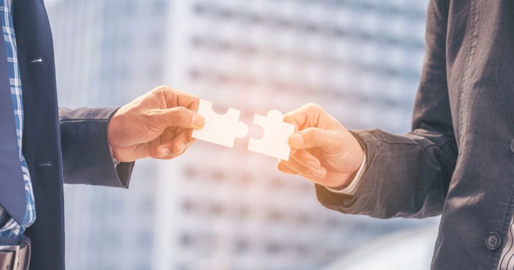 two people joining two pieces of a puzzle to signify building trust