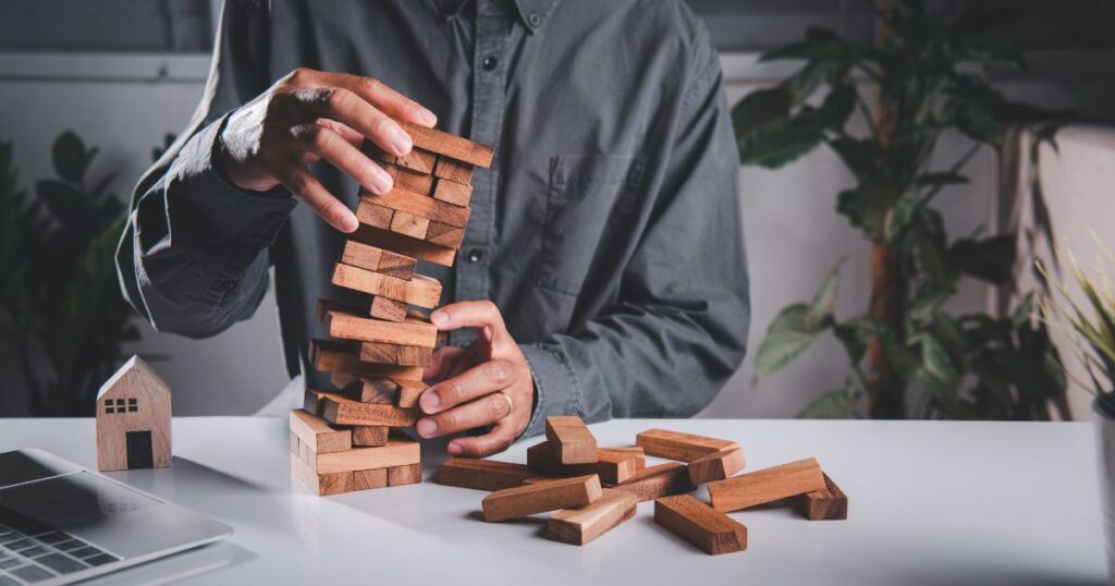 a man stacking wooden blocks to signify the challenges in setting remote work goals and expectations