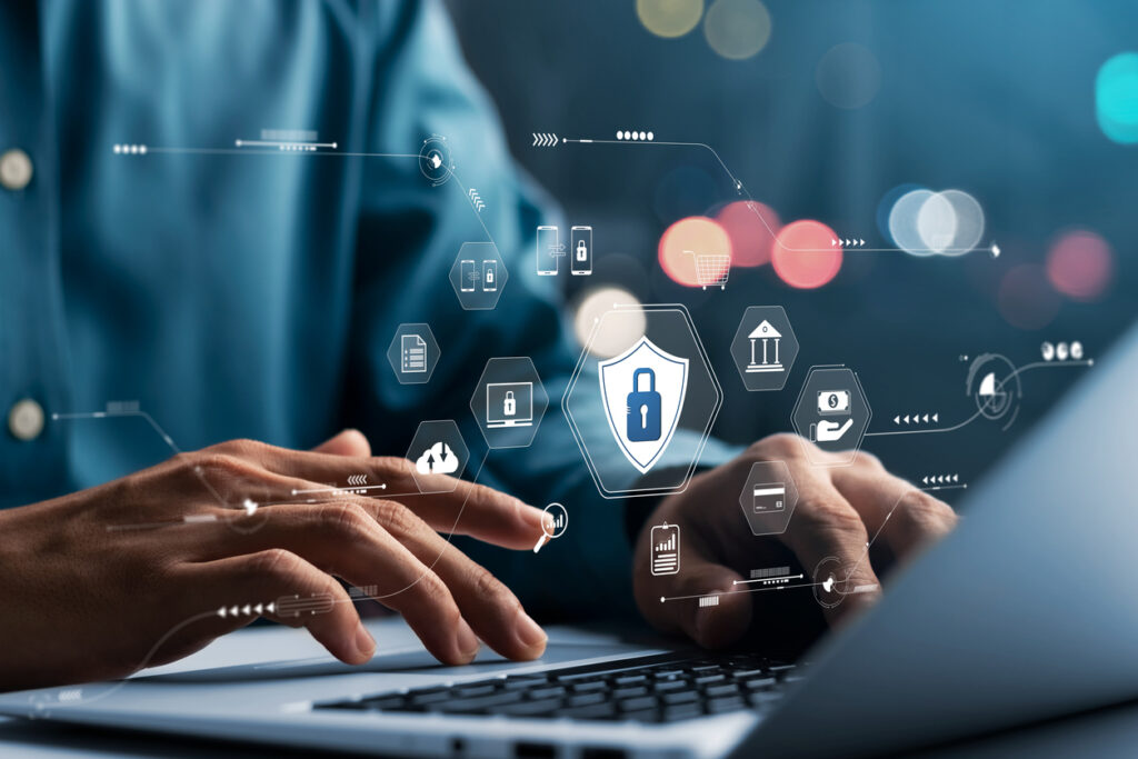 man typing in a laptop with remote work data security icons hovering above the keyboard