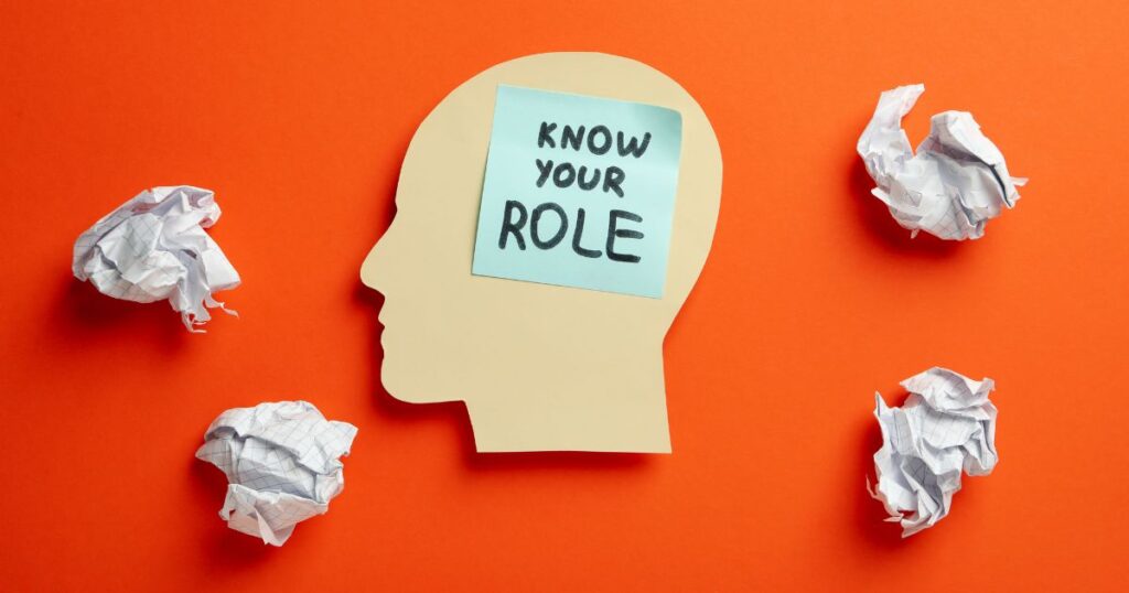 cut out of a person's head with a sticky note that says "know your role"