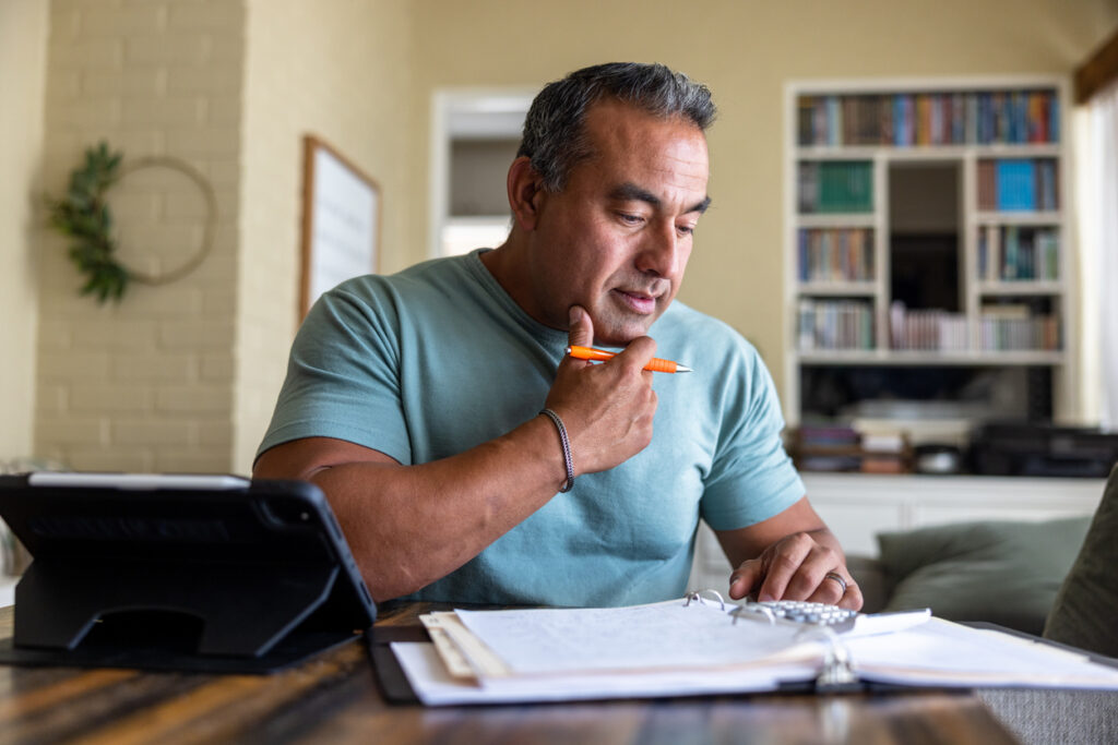 a man doing taxes while holding a pen