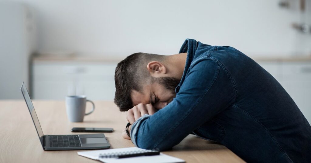 a tired man sleeping on a table