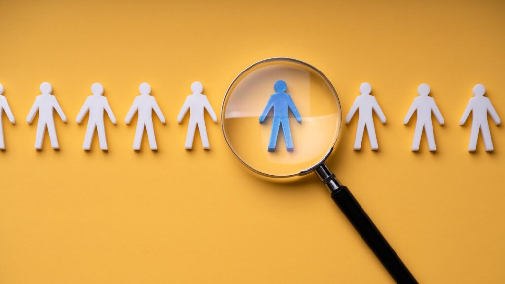 white human cutouts; magnifying glass over a blue cutout to depict best practices for remote staffing