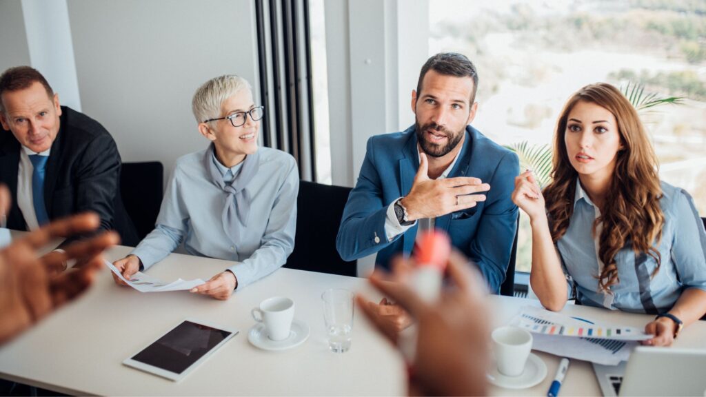 a person talking to a group of employees with different ages